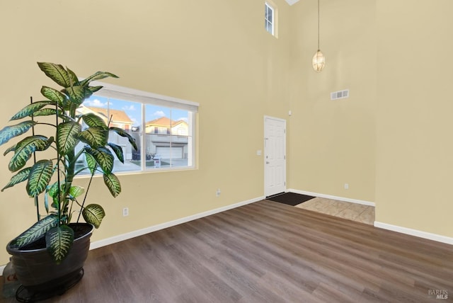 entrance foyer with wood-type flooring and a high ceiling