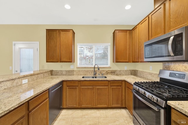 kitchen featuring light stone countertops, sink, light tile patterned floors, and stainless steel appliances