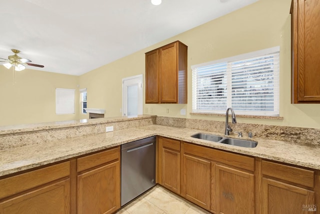 kitchen featuring light stone counters, stainless steel dishwasher, ceiling fan, and sink