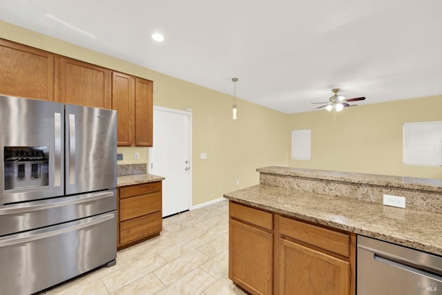 kitchen featuring light stone countertops, stainless steel appliances, and ceiling fan