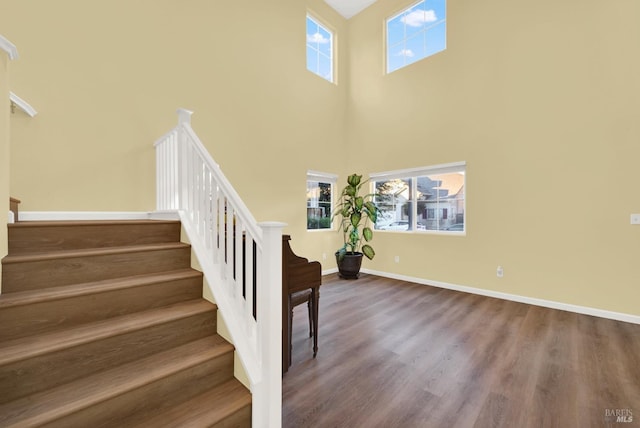 stairs featuring hardwood / wood-style floors and a towering ceiling