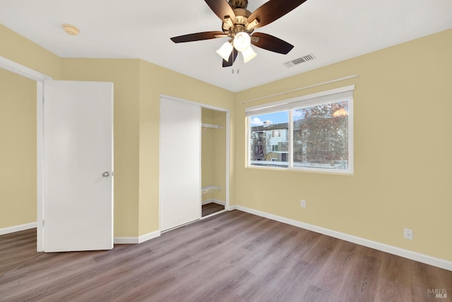 unfurnished bedroom featuring ceiling fan, a closet, and light wood-type flooring