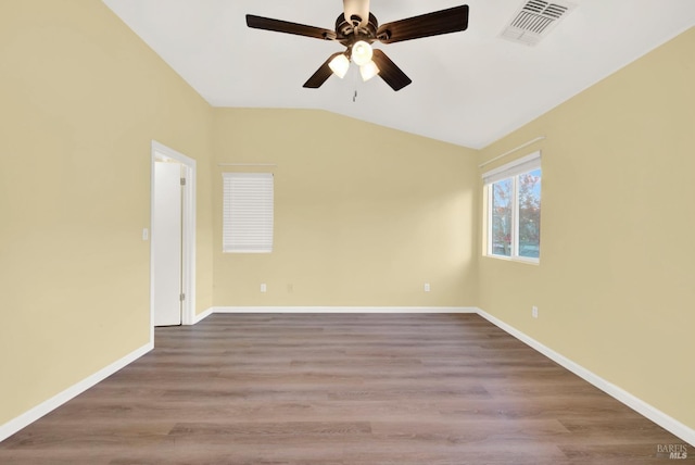 empty room featuring ceiling fan, vaulted ceiling, and light wood-type flooring