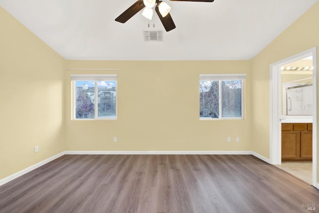 empty room with ceiling fan, light wood-type flooring, and vaulted ceiling