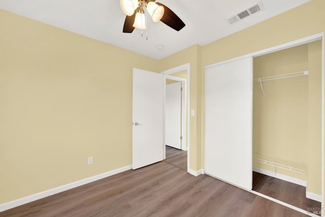 unfurnished bedroom with wood-type flooring, a closet, and ceiling fan