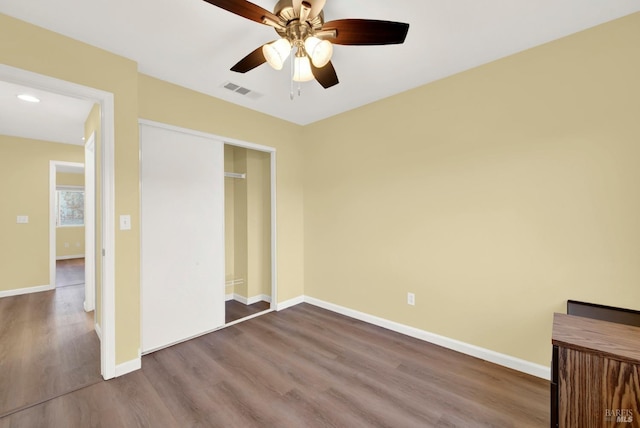 unfurnished bedroom with hardwood / wood-style floors, ceiling fan, and a closet