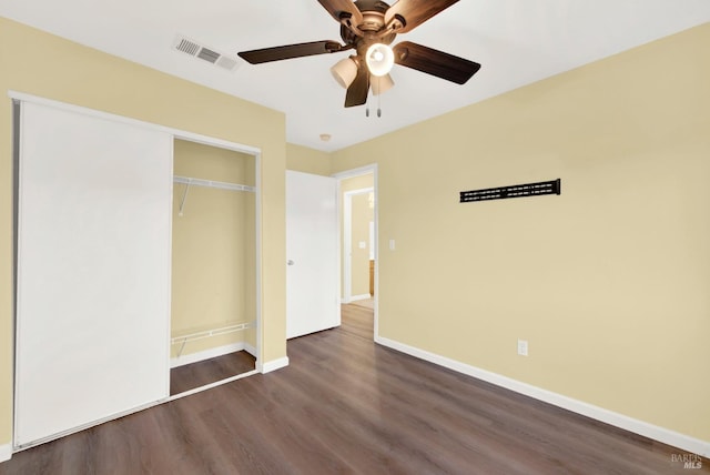 unfurnished bedroom featuring ceiling fan, dark wood-type flooring, and a closet