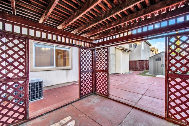 view of patio / terrace with cooling unit and a storage shed