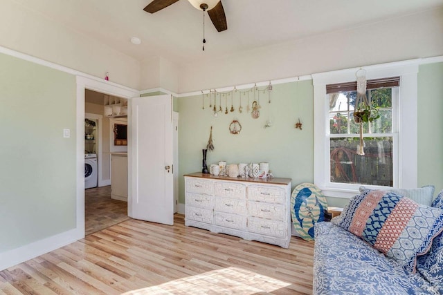 sitting room with washer / dryer, ceiling fan, and light wood-type flooring