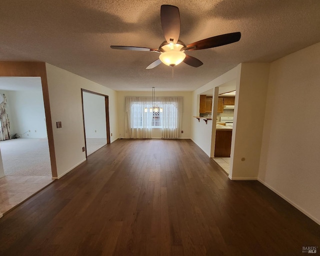 unfurnished living room with ceiling fan, dark wood-type flooring, and a textured ceiling