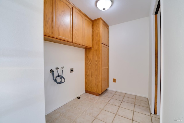 washroom with light tile patterned floors, hookup for a washing machine, cabinet space, electric dryer hookup, and baseboards