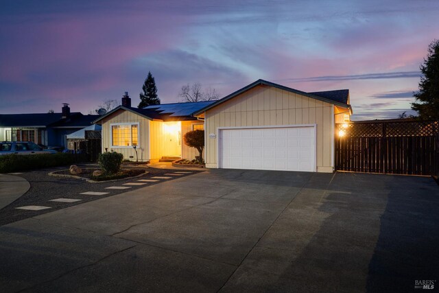 ranch-style home featuring solar panels and a garage