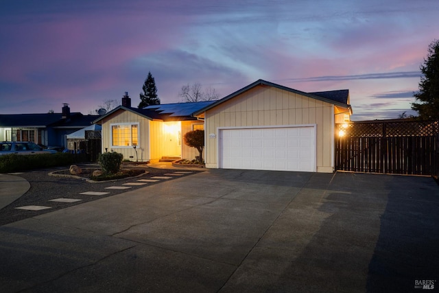 ranch-style home with a garage, driveway, and fence