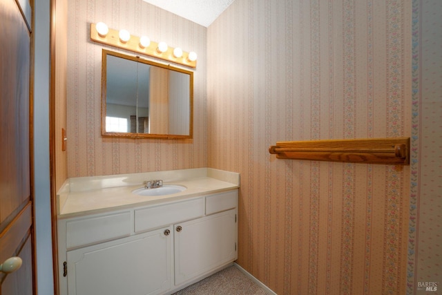 bathroom featuring wallpapered walls and vanity