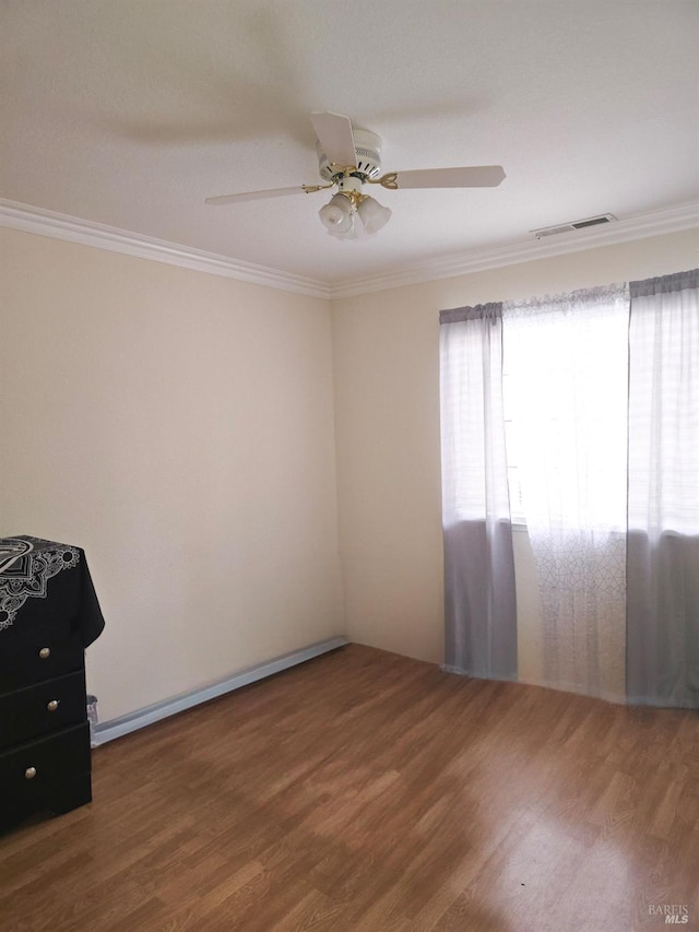 spare room featuring hardwood / wood-style flooring, ceiling fan, and ornamental molding