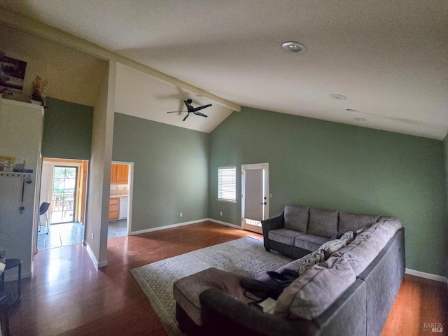 living room with vaulted ceiling with beams, ceiling fan, and dark hardwood / wood-style floors