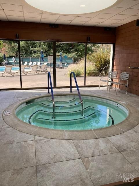 view of swimming pool featuring a community hot tub and a patio area