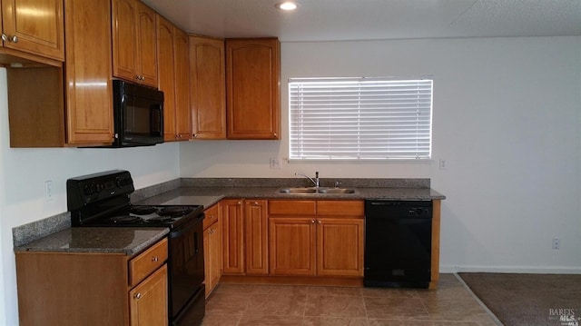 kitchen featuring sink, dark tile patterned flooring, and black appliances