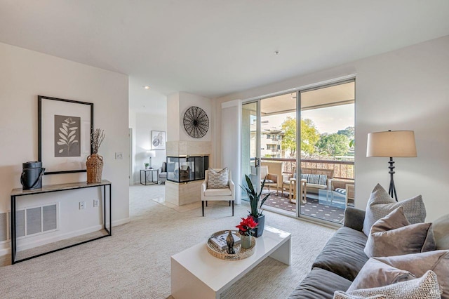 carpeted living room with a tiled fireplace