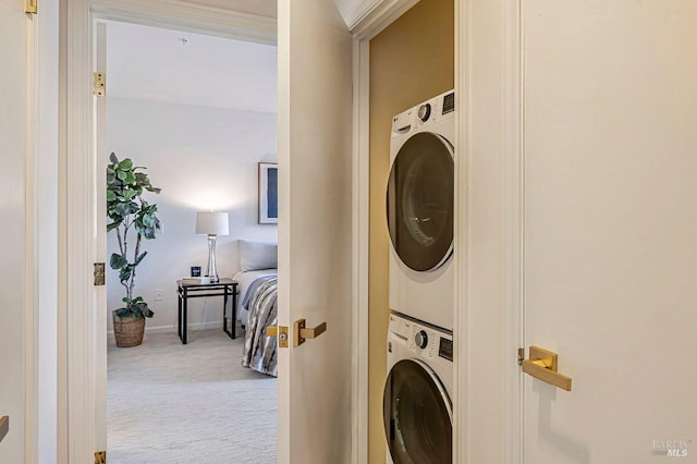 laundry room with light carpet and stacked washer and dryer