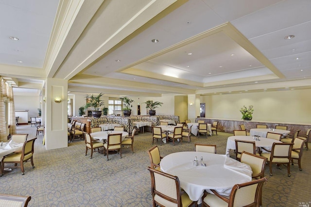 dining area featuring a raised ceiling, carpet floors, and crown molding