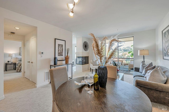 carpeted dining room with a multi sided fireplace