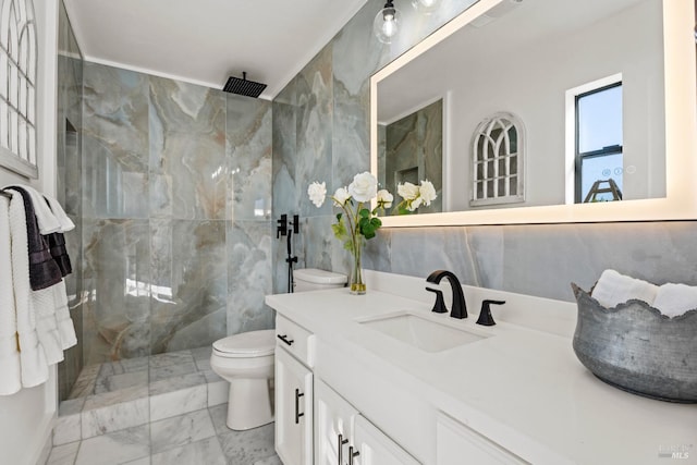 bathroom featuring tiled shower, vanity, toilet, and tile walls