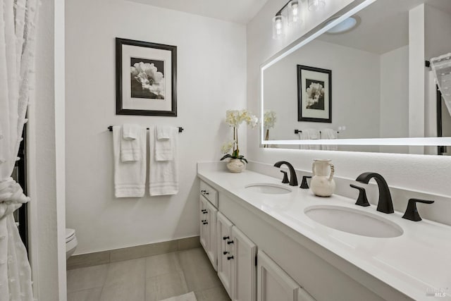 bathroom featuring tile patterned floors, vanity, and toilet