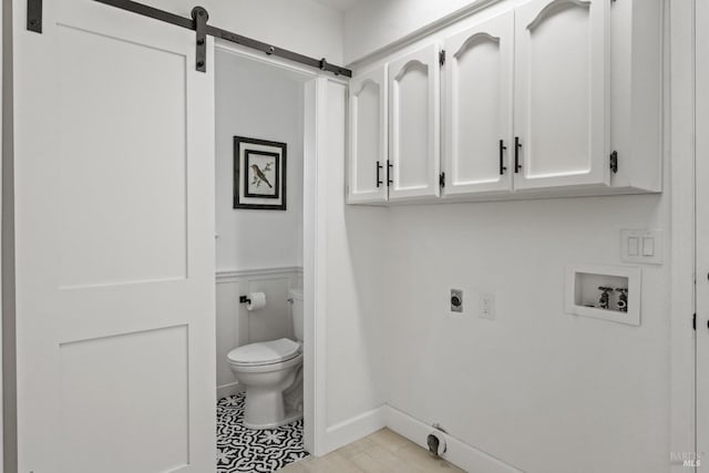 laundry room with cabinets, hookup for a washing machine, a barn door, and electric dryer hookup