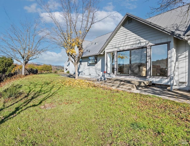 rear view of property with a lawn