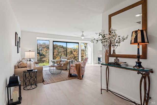 living room featuring light hardwood / wood-style floors and ceiling fan