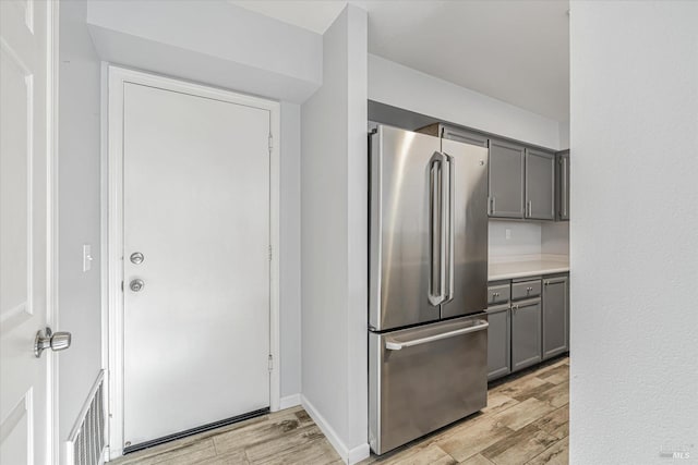 kitchen with light hardwood / wood-style floors, high end fridge, and gray cabinetry