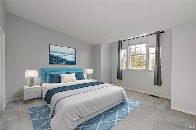 carpeted bedroom with lofted ceiling