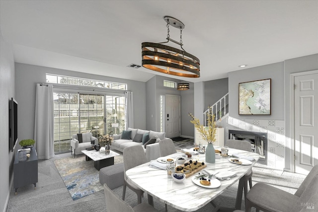 dining space featuring light carpet and a notable chandelier