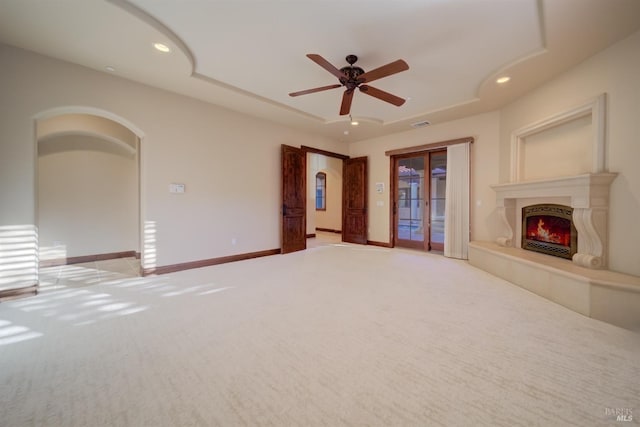 unfurnished living room featuring light colored carpet and ceiling fan