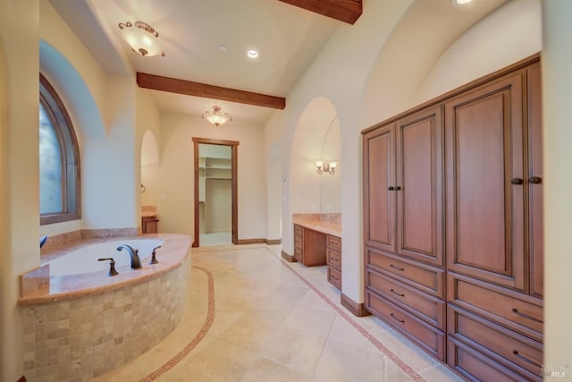 bathroom with beamed ceiling, vanity, a relaxing tiled tub, and tile patterned flooring