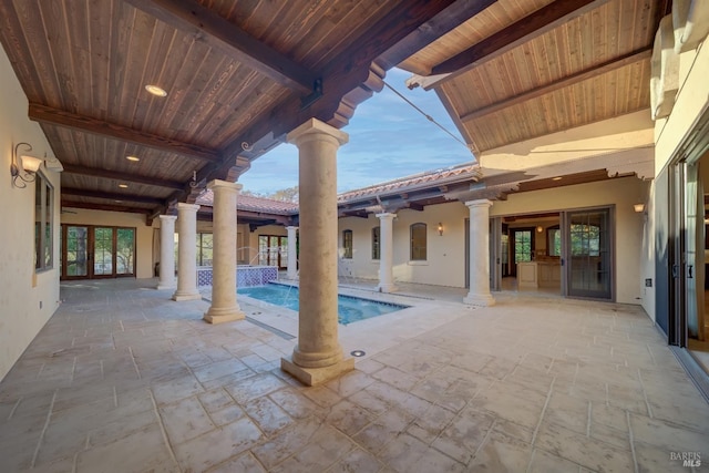 view of pool with pool water feature, a patio area, and french doors