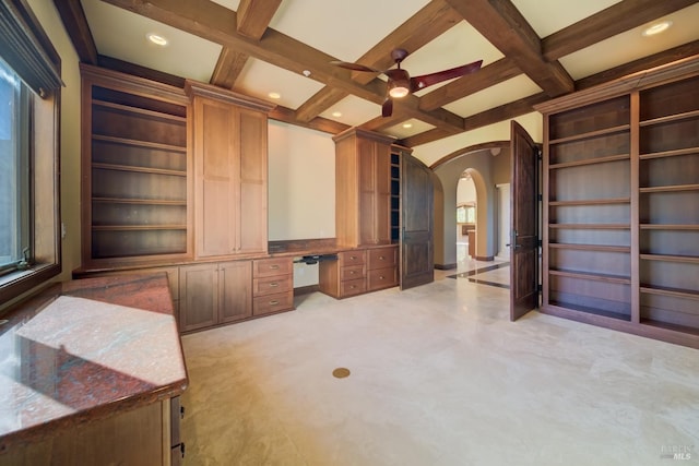 interior space with beamed ceiling, built in desk, ceiling fan, and coffered ceiling