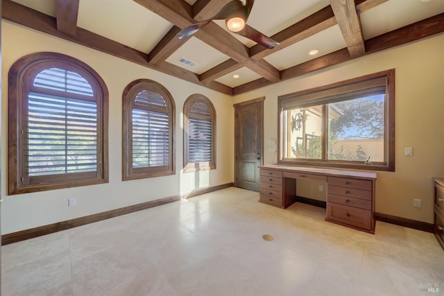 unfurnished office featuring beam ceiling, built in desk, a wealth of natural light, and coffered ceiling