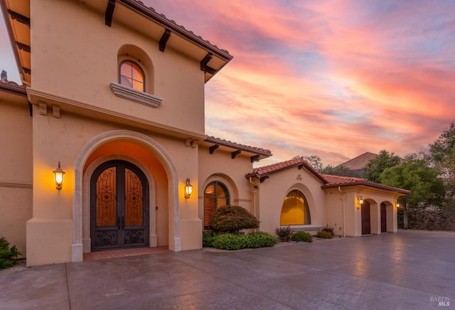 mediterranean / spanish-style house with french doors and a garage