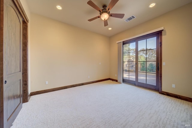 empty room featuring ceiling fan and light colored carpet