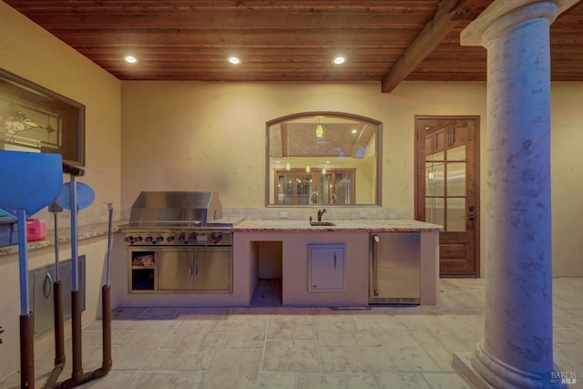 kitchen featuring beamed ceiling, stainless steel refrigerator, wooden ceiling, and ornate columns