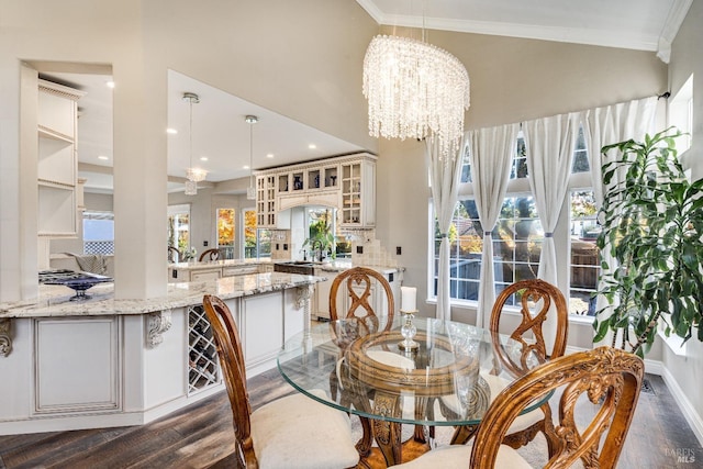 dining space featuring crown molding, an inviting chandelier, dark wood-type flooring, and sink