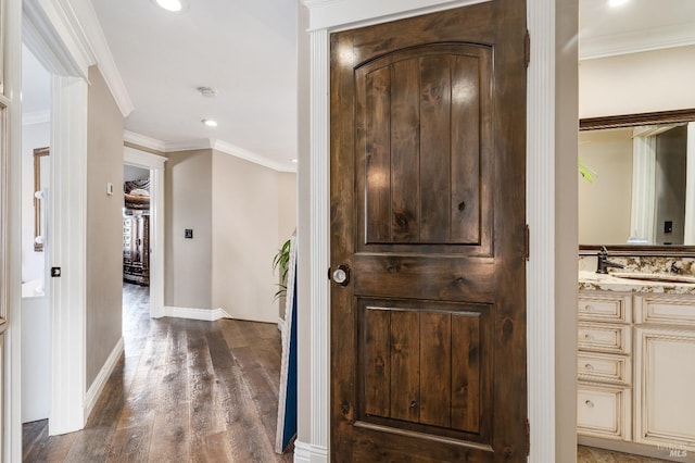 hall featuring sink, dark hardwood / wood-style flooring, and ornamental molding