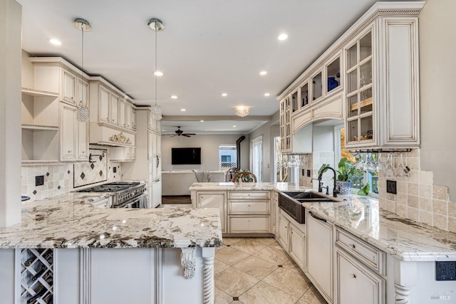 kitchen with kitchen peninsula, light stone counters, high end range, and pendant lighting