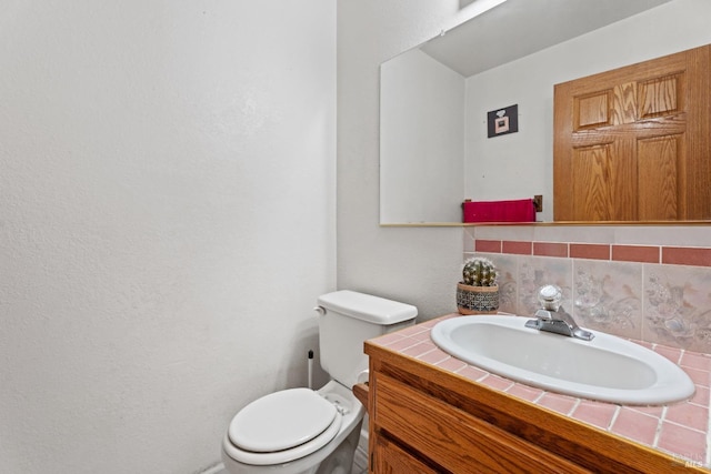 bathroom with tasteful backsplash, vanity, and toilet