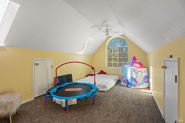 recreation room featuring carpet, lofted ceiling with skylight, and ceiling fan