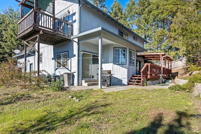 back of property featuring a lawn and a wooden deck