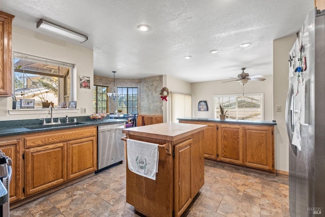 kitchen featuring appliances with stainless steel finishes, a kitchen island, a wealth of natural light, and sink