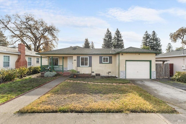 single story home with covered porch, a garage, and a front yard